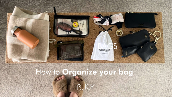 accessories lying on a table, with the text "how to organize your bag"